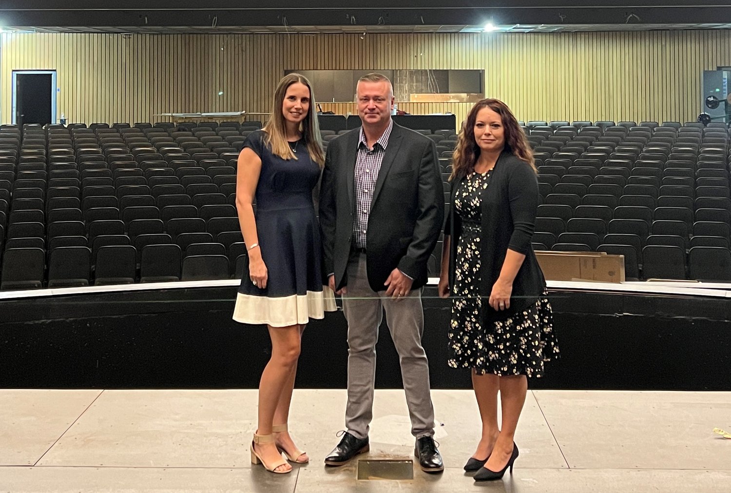 Emily Burcham and Jeremy Burcham, owners of Meridian Title, and Tricia Chapman, sponsorship coordinator for Nixa Public Schools, showcase the performance hall inside of the Aetos Center for The Performing Arts.